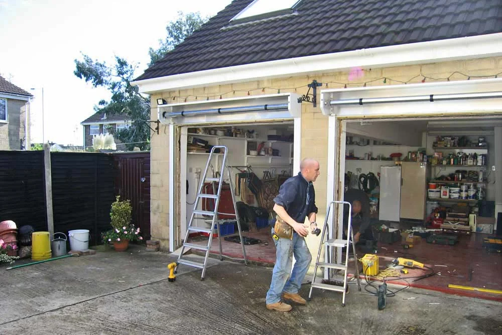 Technician installing roller garage doors
