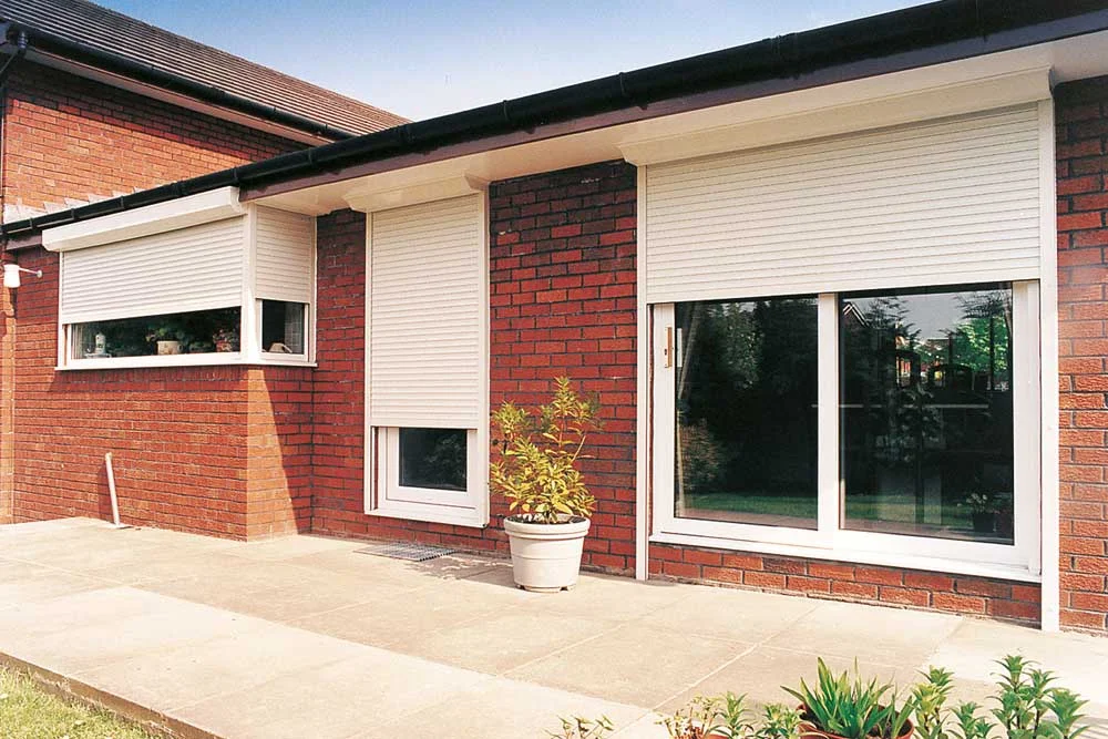 White roller shutters on a brick house